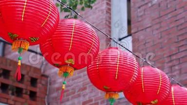 美丽的圆形红灯笼挂在古老的传统街道上，中国农历新年的概念，特写。 下面